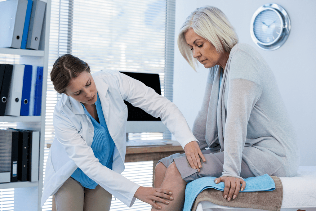 Un paciente con osteoartritis que necesita terapia siendo examinado por un médico